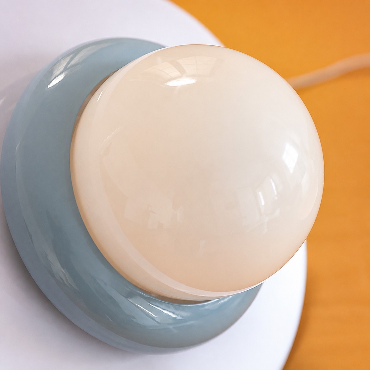Close-up of opal glass globe diffuser and blue shade